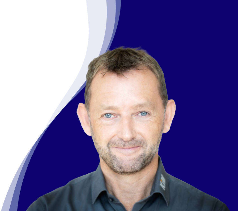 Achim Angel, Managing Director of KiM GmbH - Member of 4PACE, smiles friendly into the camera. He has short brown hair, a short beard and is wearing a dark gray shirt with a slightly open collar. A curved wave shape in white, light blue and dark blue can be seen in the background, giving the picture a modern design.