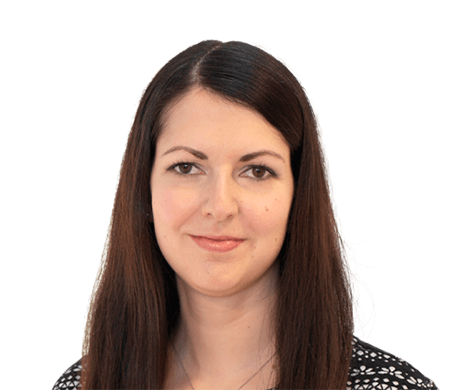 Julia Multhammer de l'entreprise Max Frank regarde aimablement la caméra. Elle a de longs cheveux lisses brun foncé avec une raie au milieu et porte un haut avec des motifs noirs et blancs.